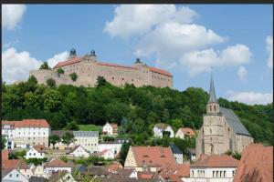 a large castle on top of a hill with buildings at CityHome Christopher CHC in Kulmbach