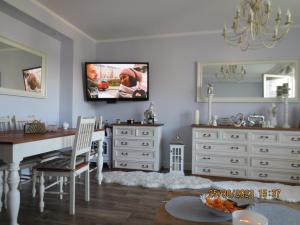 sala de estar con mesa y TV en la pared en Apartament Świnoujście, en Świnoujście