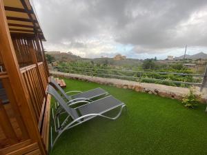 サンミゲル・デ・アボナにあるCasas Palmaの緑の芝生のあるバルコニーのベンチ