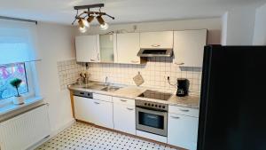 a kitchen with white cabinets and a stove top oven at Mitten in den Weinbergen in Sommerhausen +12 photos