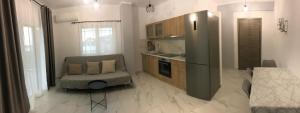 a kitchen with a couch and a chair in a room at Bafas Apartments in Plataria