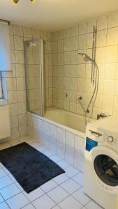 a bathroom with a washing machine and a tub at Mitten in den Weinbergen in Sommerhausen