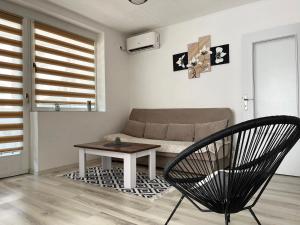 Starlux apartment في موستار: غرفة معيشة مع أريكة وطاولة وكرسي