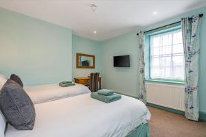 1 dormitorio con 2 camas y ventana en The Queens en Carlisle