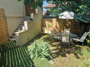 un patio con mesa, sillas y una valla en Appartement indépendant dans maison avec jardinet, au calme, en Sérézin-du-Rhône
