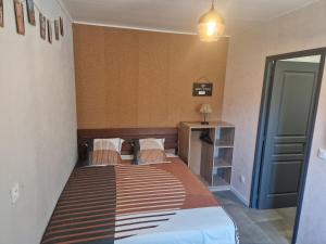 una camera con letto e testiera in legno di Appartement indépendant dans maison avec jardinet, au calme a Sérézin-du-Rhône