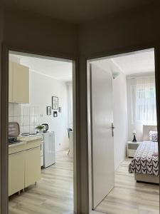 a room with a kitchen and a bedroom with a bed at Starlux apartment in Mostar