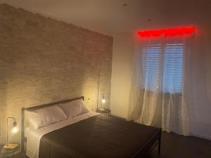 a bedroom with a bed and a window with red lights at AL MAR 38 in Brindisi