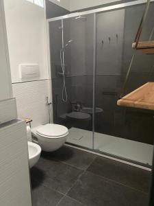 a bathroom with a toilet and a glass shower at AL MAR 38 in Brindisi