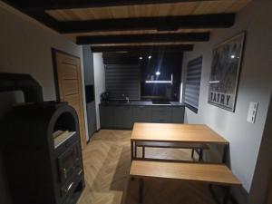 a small room with a table and a kitchen at Hubacówka in Huba