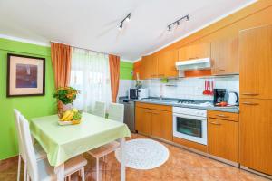 a kitchen with a table and a kitchen with green walls at Denis in Vodnjan