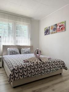 Starlux apartment في موستار: غرفة نوم بسرير عليها شريط وردي