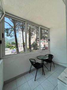 Starlux apartment في موستار: غرفة بطاولة وكرسيين ونافذة