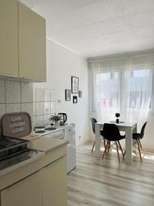 een witte keuken met een tafel en een eetkamer bij Starlux apartment in Mostar