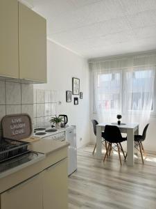 a white kitchen with a table and a dining room at Starlux apartment in Mostar