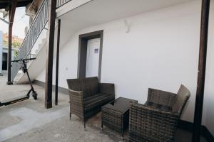 Dos sillas de mimbre y una mesa en un edificio en Apartmani Otašević, en Kladovo