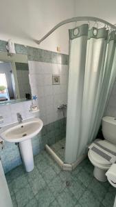een badkamer met een douche, een wastafel en een toilet bij Summer Times Studios in Naxos Chora