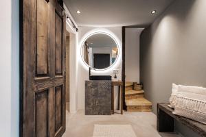 bagno con porta in legno e specchio di Bäcksteinerhof a Merano