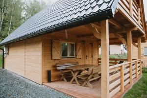 a wooden cabin with a table and a roof at Domek na Groniku in Zubrzyca Górna
