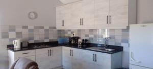 a kitchen with white cabinets and a sink and a clock at Abundant Grace in Montagu +54 photos