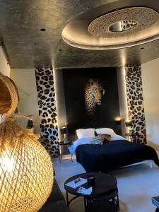 una camera con letto blu e soffitto con aigunigunigun di Esprit AFRICA, SPA et SAUNA de luxe a Mulhouse
