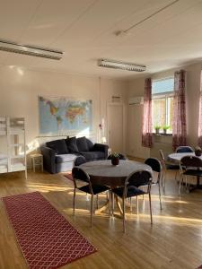 a living room with a couch and a table and chairs at Kalvs Skolhus in Kalv