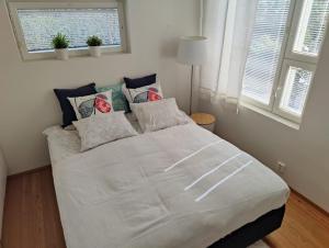 ein weißes Bett in einem Zimmer mit 2 Fenstern in der Unterkunft Kotoisa Parkkipaikallinen Kaksio Kangasalan Keskustassa in Kangasala