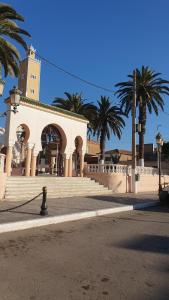 a building with palm trees in front of a street at Villa 250 m2 terrasse plus Garage in Mostaganem +1 photo