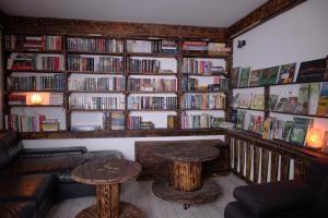 a living room with two tables and a book shelf filled with books at Kongres Czarownic in Zagnańsk