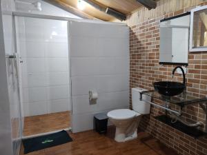 La salle de bains est pourvue de toilettes et d'un lavabo. dans l'établissement Rancho Hanna - Pousada, Camping e Comidaria, à Iporanga