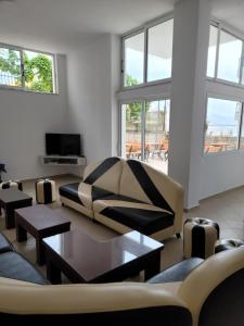 a living room with a couch and tables and windows at Hostel K13 in Sarandë