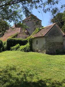 una vieja casa de piedra en un campo de hierba en Chateau de Vesset, en Tréteau