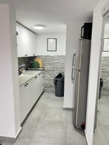 a kitchen with white cabinets and a refrigerator at Beautiful design Studio in Rishon LeẔiyyon