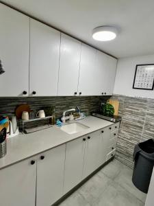 a kitchen with white cabinets and a sink at Beautiful design Studio in Rishon LeẔiyyon