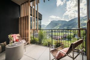 a balcony with a table and chairs and a view of mountains at Coolnest in Mayrhofen