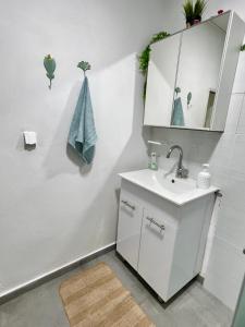 a bathroom with a sink and a mirror at Beautiful design Studio in Rishon LeẔiyyon
