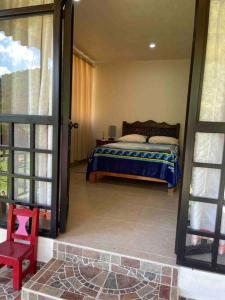 1 dormitorio con 1 cama y 1 habitación con ventana en Hermosa casita con vista al río., en San Cristóbal de Las Casas
