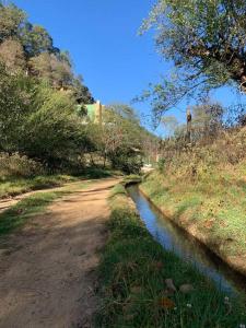un camino de tierra junto a un pequeño río en Hermosa casita con vista al río., en San Cristóbal de Las Casas