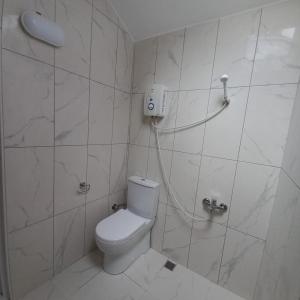 y baño blanco con aseo y ducha. en Newsuit2023, en Trabzon