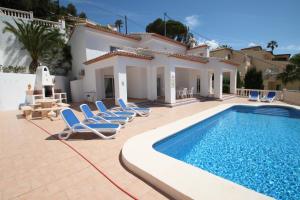 uma villa com uma piscina e espreguiçadeiras em Sesam - sea view villa with private pool in Moraira em Moraira