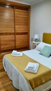 ein Schlafzimmer mit einem Bett mit zwei Handtüchern darauf in der Unterkunft A Casa de Lamas in Meis