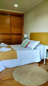 Schlafzimmer mit einem großen weißen Bett mit einem Kopfteil aus Holz in der Unterkunft A Casa de Lamas in Meis