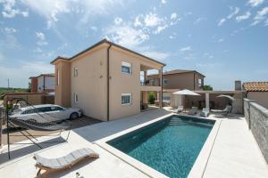 eine Villa mit Swimmingpool und ein Haus in der Unterkunft Villa Maslina in Vodnjan