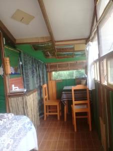 a room with a bed and a table and chairs at Los Aventureros in Samaipata