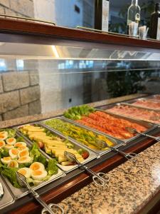 un buffet avec de nombreux types de nourriture différents dans l'établissement Hotel Excelsior Bay, à Malcesine