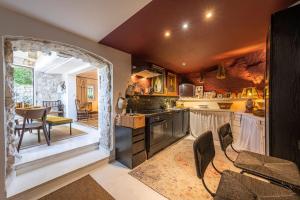 a kitchen with an archway and a table and chairs at le Balcon du Prince Noir in Les Baux-de-Provence