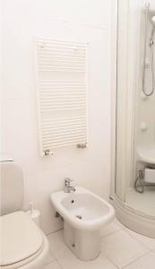 La salle de bains blanche est pourvue de toilettes et d'un lavabo. dans l'établissement [MARE] Luminoso appartamento - Sabrina, à Alassio