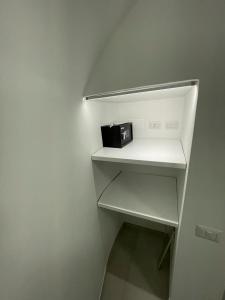 a white refrigerator with a white shelf with a toaster on it at Sea Paradise in Gallipoli