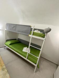 a bunk bed with green sheets and towels on it at Sea Paradise in Gallipoli