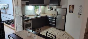 a small kitchen with a table and a refrigerator at Departamento Alem in Posadas